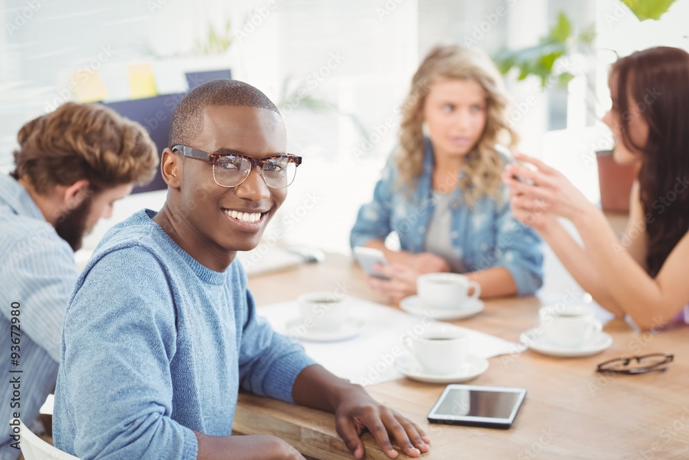 Portrait of smiling man wearing eyeglasses while sitting at desk Portrait of smiling man wearing eyeglasses while sitting at desk
