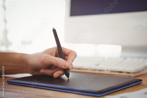 Cropped hand of man working on graphics tablet