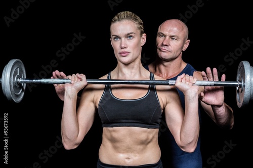 Trainer assisting woman for lifting crossfit