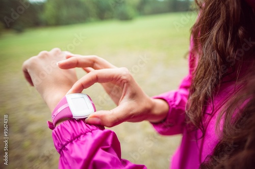 Woman using her smartwatch on a hike