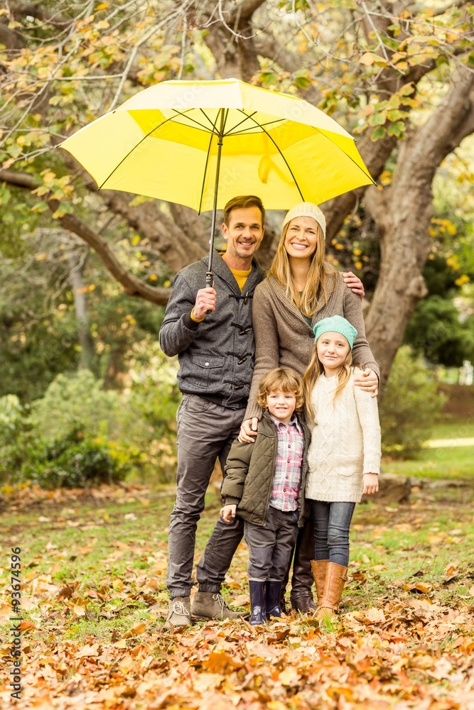 Smiling young family under umbrella