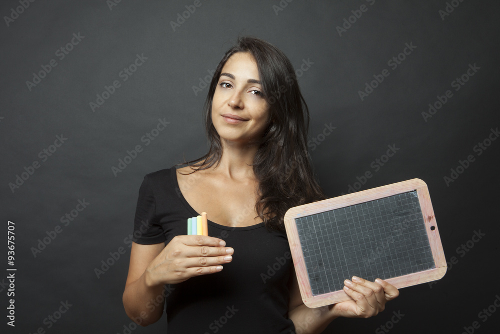 Bellissima ragazza con espressione sorridente mostra una lavagna Bellissima ragazza con espressione sorridente mostra una lavagna