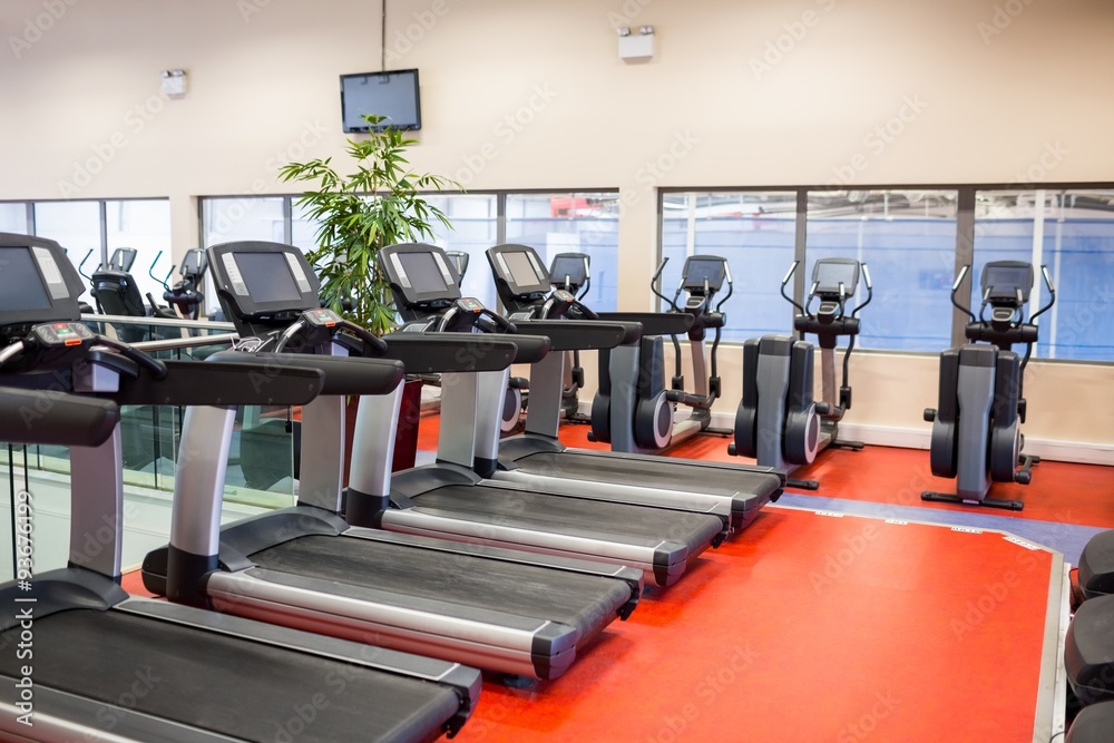Fototapeta premium Row of treadmills and exercise bikes