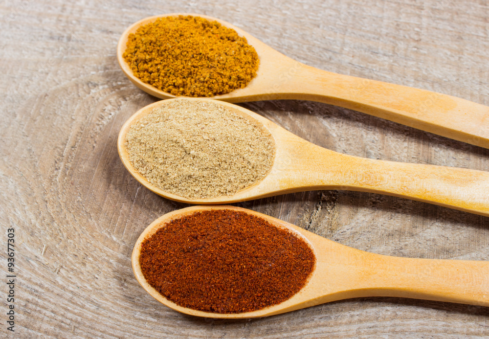 Spice powder on a wooden background. Closeup on paprika, curry and ginger. Spice powder on a wooden background. Closeup on paprika, curry and ginger.