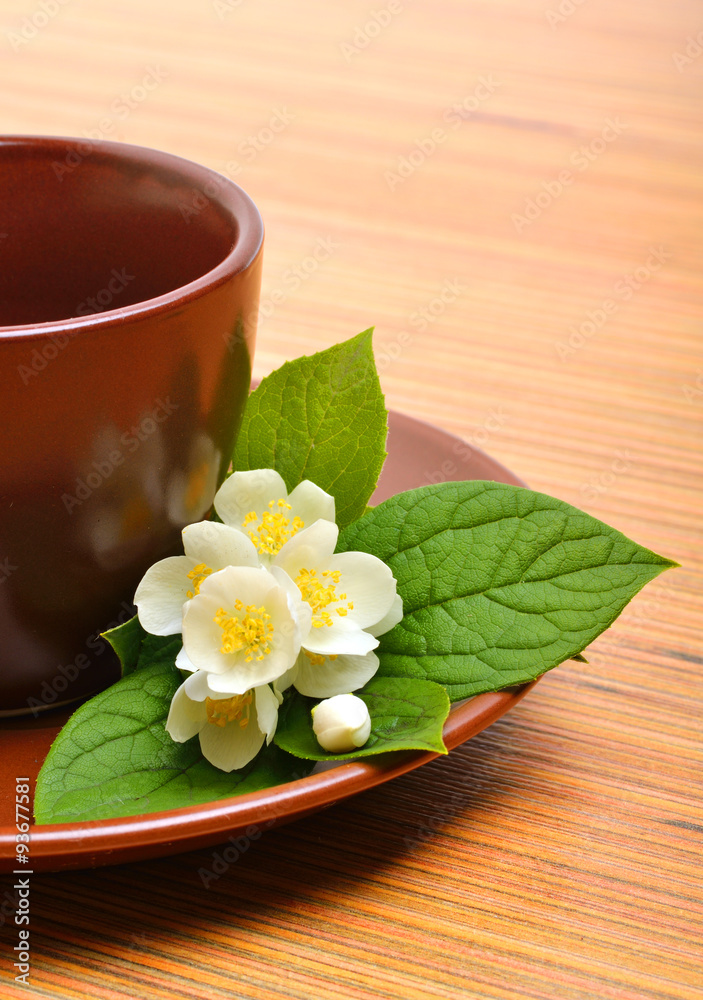 tea cup with jasmine flower on wood
