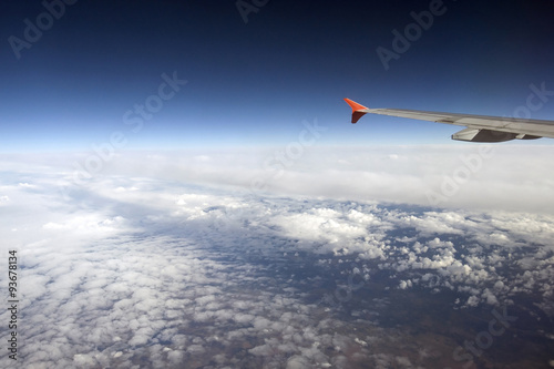 Wing of the Airbus above the clouds in the sky, view from above the clouds, flying over clouds in plane, space, weather and climate for flying, the atmosphere and the stratosphere, meteorology.