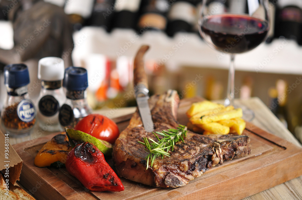 T-Bone steak barbecue with fried potato and red wine on wood table