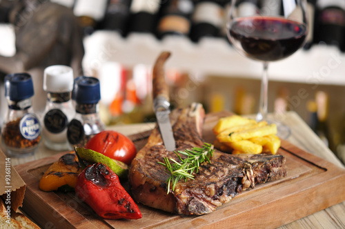 T-Bone steak barbecue with fried potato and red wine on wood table