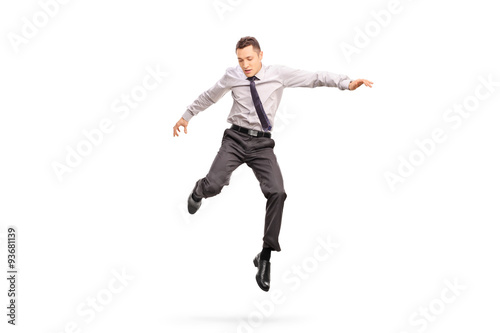 Businessman jumping in the air and looking down