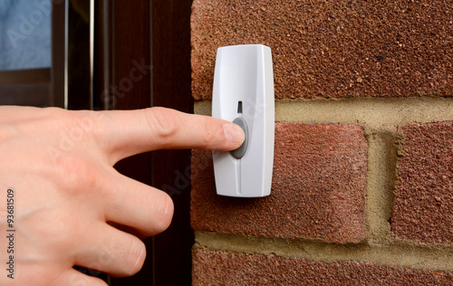 Slika na platnu Close-up of woman pressing a doorbell