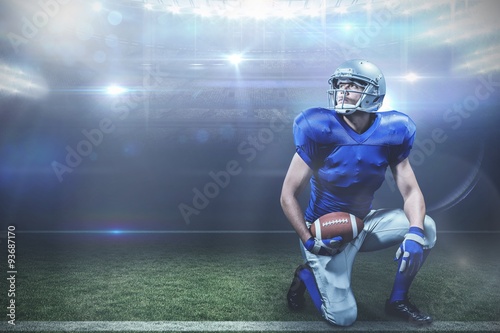 Composite image of american football player with ball kneeling © vectorfusionart