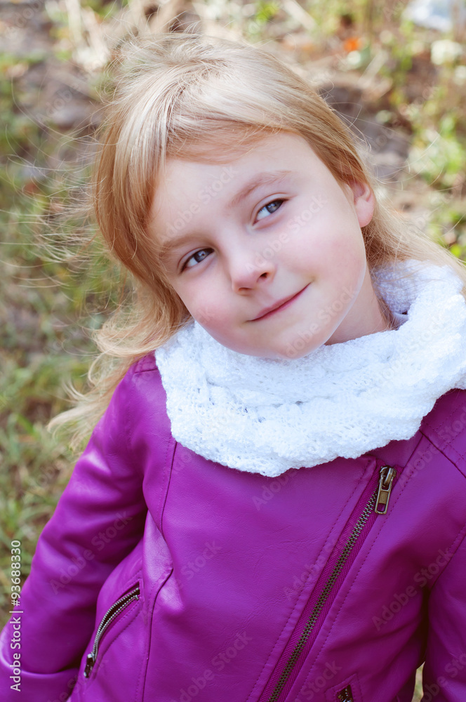 Cute little blond girl in a white scarf looking like a daredevil Cute little blond girl in a white scarf looking like a daredevil