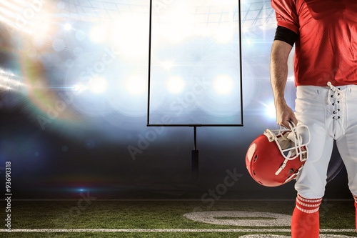 Front view of American football player holding his helmet against american football arena © vectorfusionart