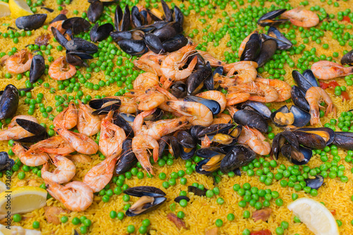  Large pan of paella with mussels, prawns; rice and peas.