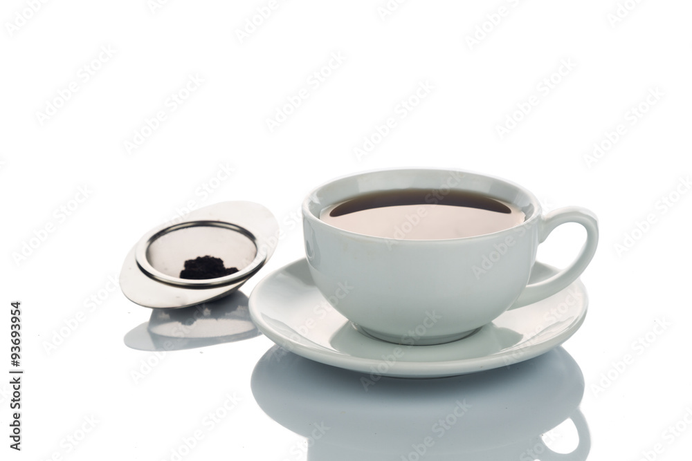 Freshly brewed hot tea in cup saucer with tea sieve Freshly brewed hot tea in cup saucer with tea sieve