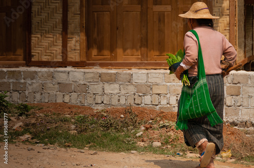 Asian person walking with a green bag photo