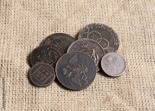 Some brass Russian Empire coins on a burlap canvas