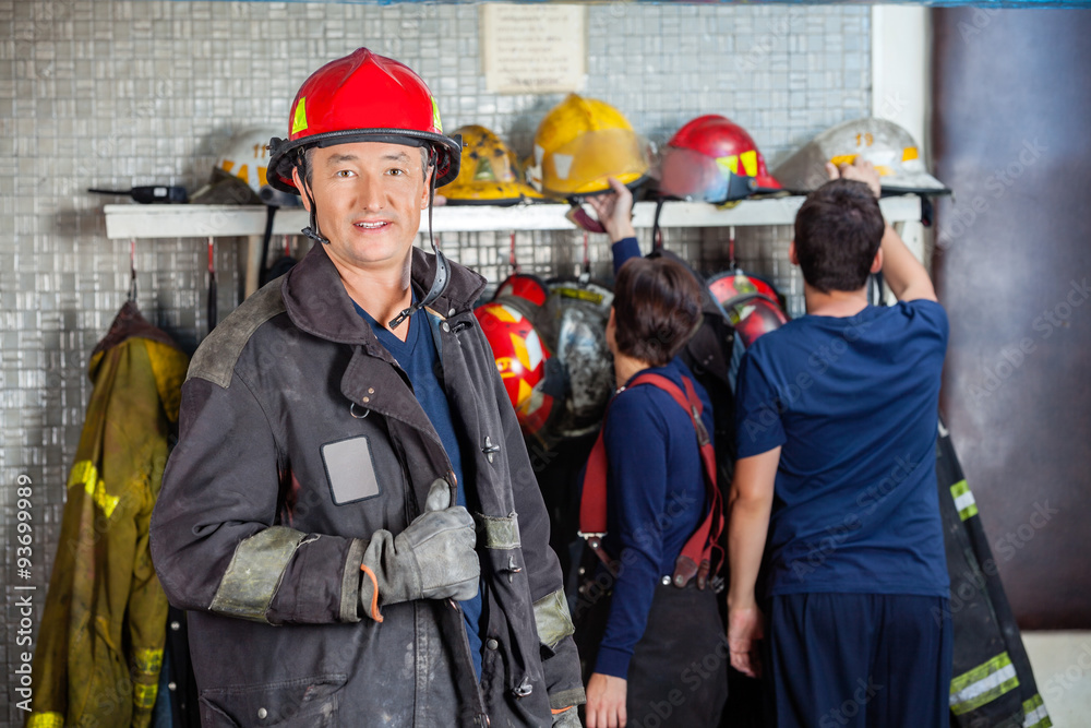 Obraz premium Smiling Fireman Standing At Fire Station