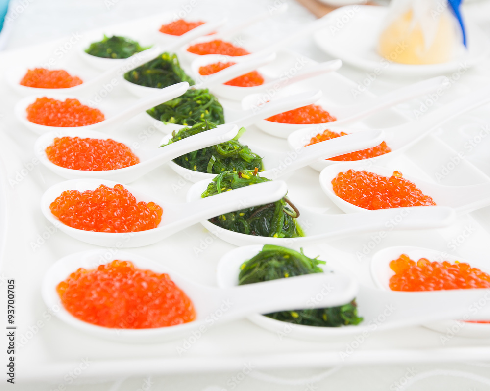 red caviar close-up in white spoons on banquet red caviar close-up in white spoons on banquet
