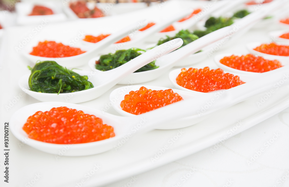 red caviar close-up in white spoons on banquet red caviar close-up in white spoons on banquet