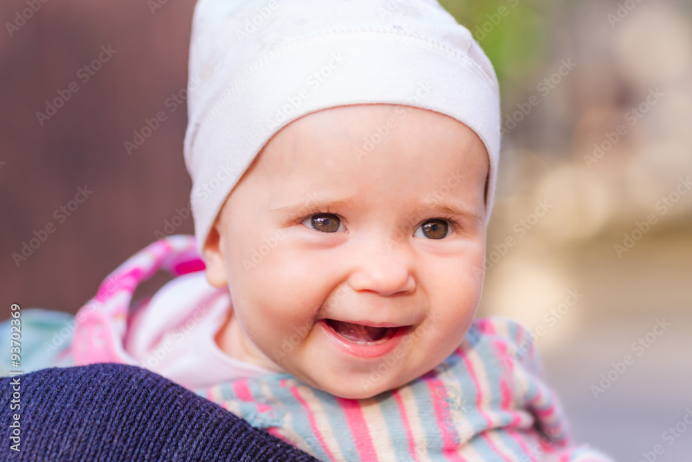 Cute baby girl looking out from mother's back Cute baby girl looking out from mother's back