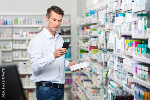 Customer Checking Information On Mobile Phone In Pharmacy © Tyler Olson