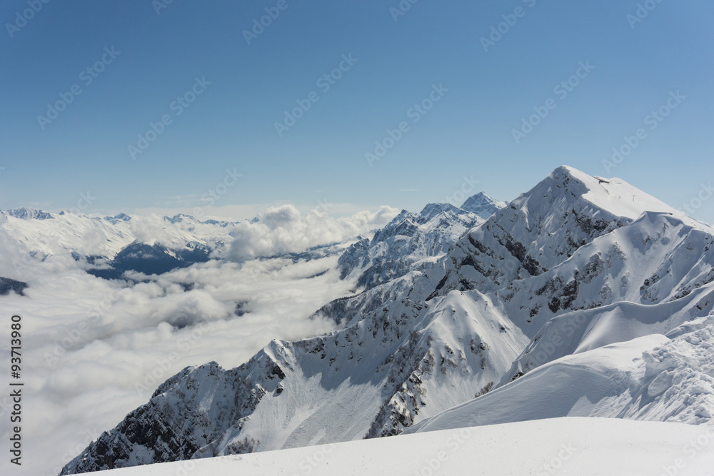 Fototapeta premium View on mountains and blue sky above clouds, Krasnaya Polyana