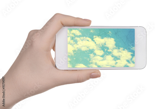 Hand holding mobile smart phone with sky in screen. Cloud computing concept