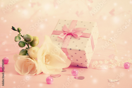 Beautiful little gift box and freesia flower on pink background