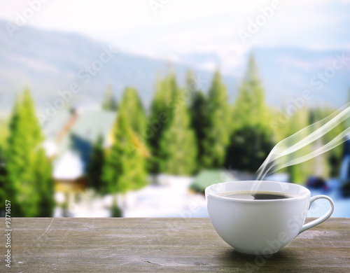 Cup of coffee on table on nature background