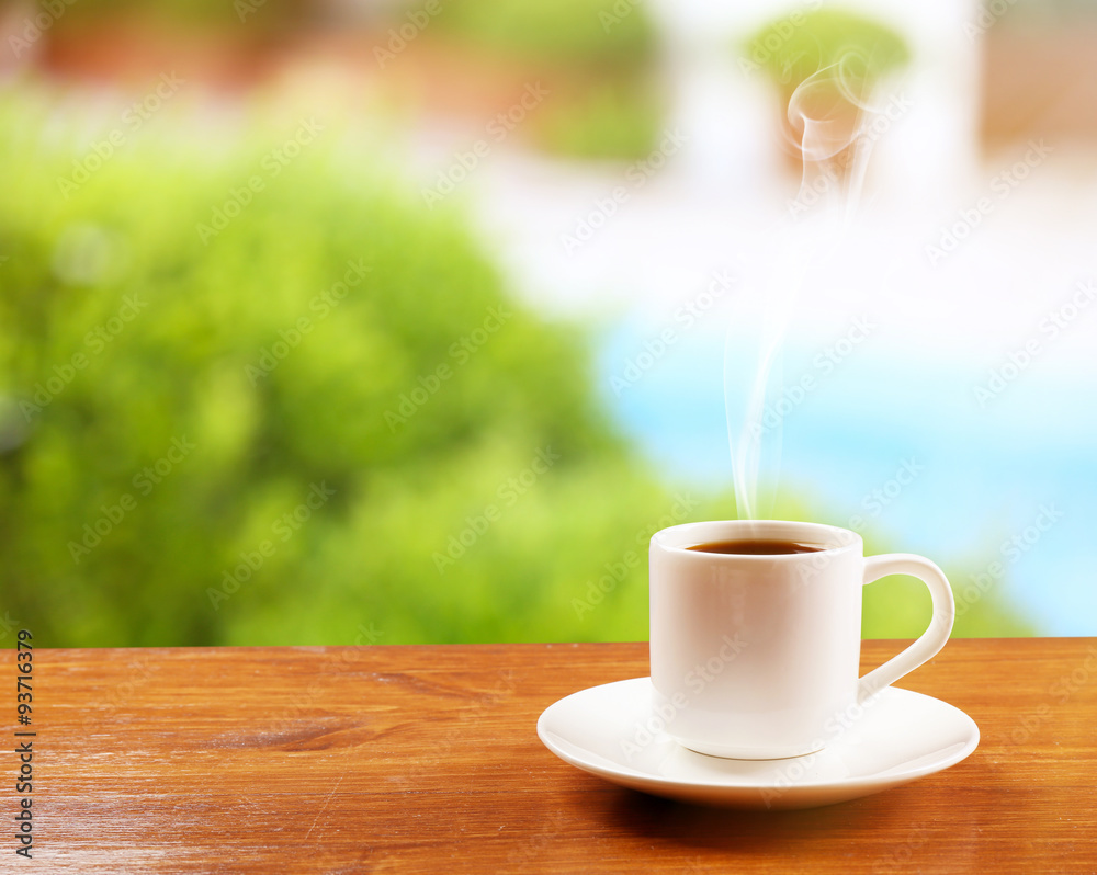 Cup of coffee on table on bright background Cup of coffee on table on bright background