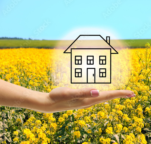 Hand holding eco house icon on nature background