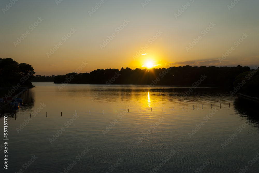 Obraz premium Sunset on the Alimini lake