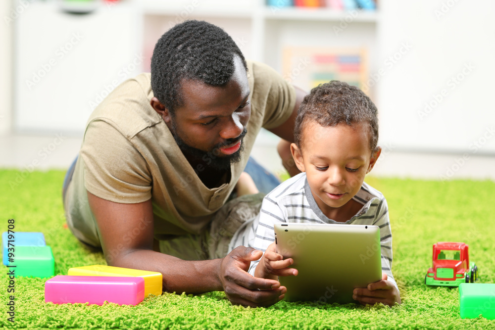 Fototapeta premium Father and son paying in the children room
