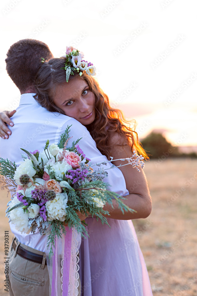 Naklejka premium the bride and groom posing at sunset