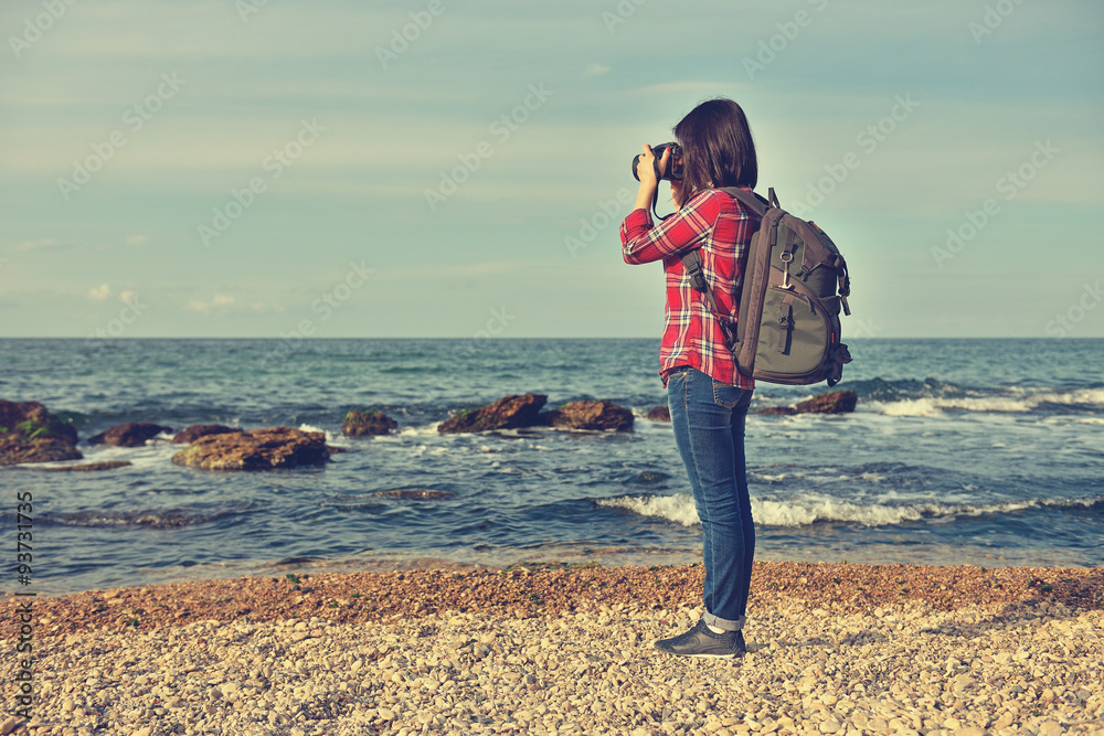 hipster girl photographing sea