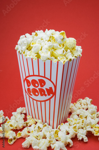 Classic box cinema popcorn on red background..