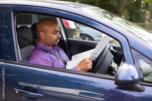 man sitting in his car reading a map © michael spring