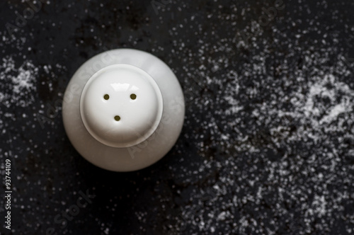 Billede på lærred Ceramic salt shaker on black background