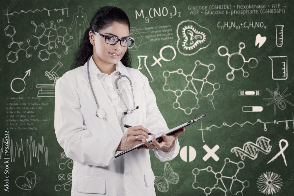 Indian doctor holds clipboard with doodle background Indian doctor holds clipboard with doodle background
