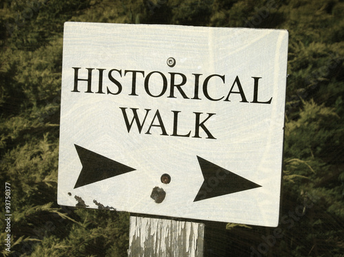 aged and worn vintage photo of historical walk sign with arrow