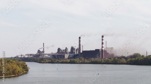 The plant at the river, heavy industry, the smoke from pipes photo