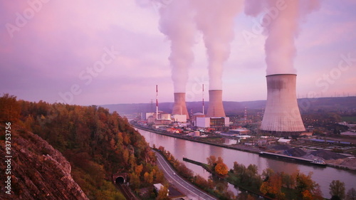 Time lapse sequence of a large nuclear power plant at a river during sunset photo