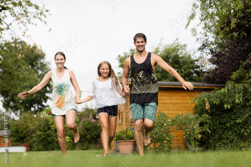 Familie läuft über einen Wassersprenger