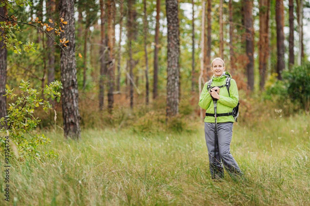 woman with hiking equipment walking in forest woman with hiking equipment walking in forest
