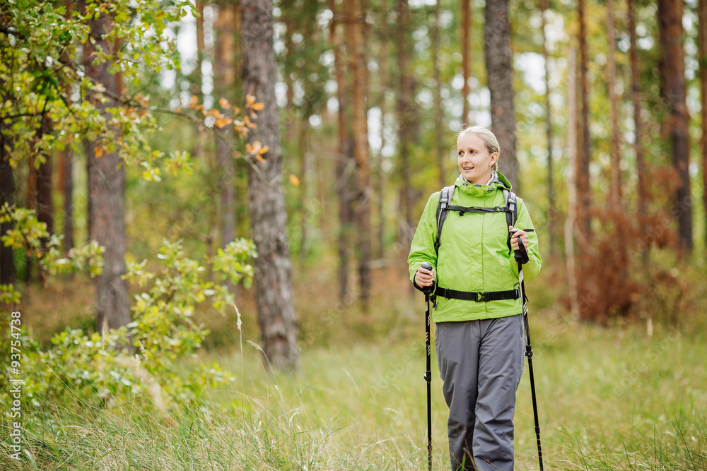 woman with hiking equipment walking in forest woman with hiking equipment walking in forest