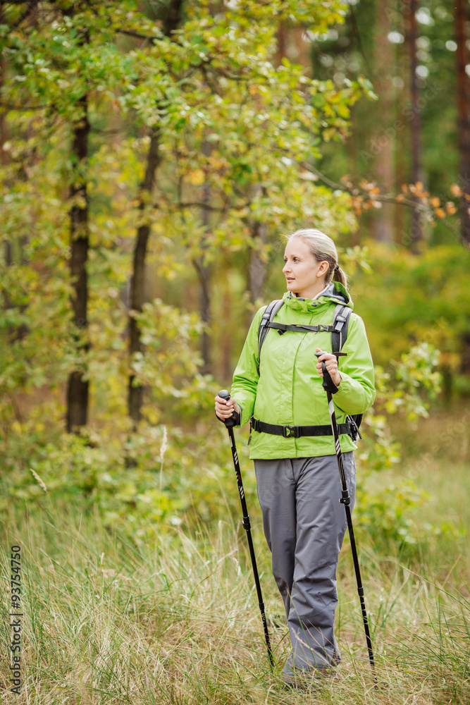 Fototapeta premium woman with hiking equipment walking in forest