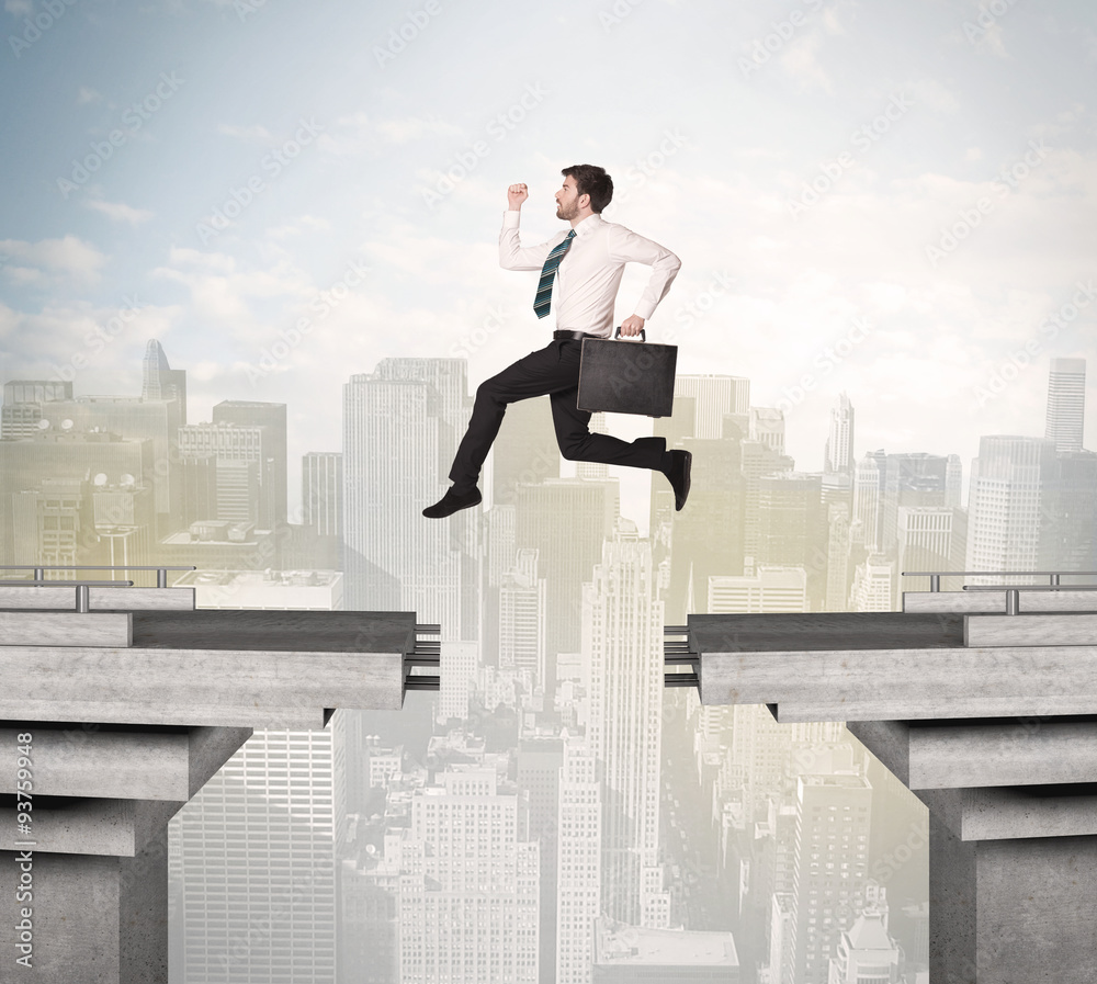Energetic business man jumping over a bridge with gap Energetic business man jumping over a bridge with gap