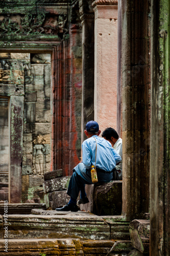 Two man sitting between stone doors © attiarndt