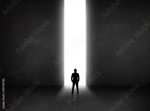 Fototapeta Business person looking at wall with light tunnel opening